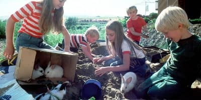 Family with children unpacking boxes in new home